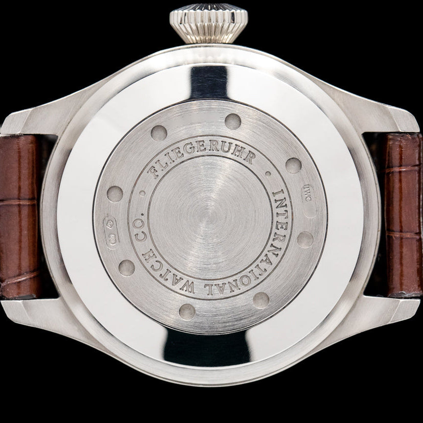 Back view of a Fliegeruhr watch with wooden strap on a black background