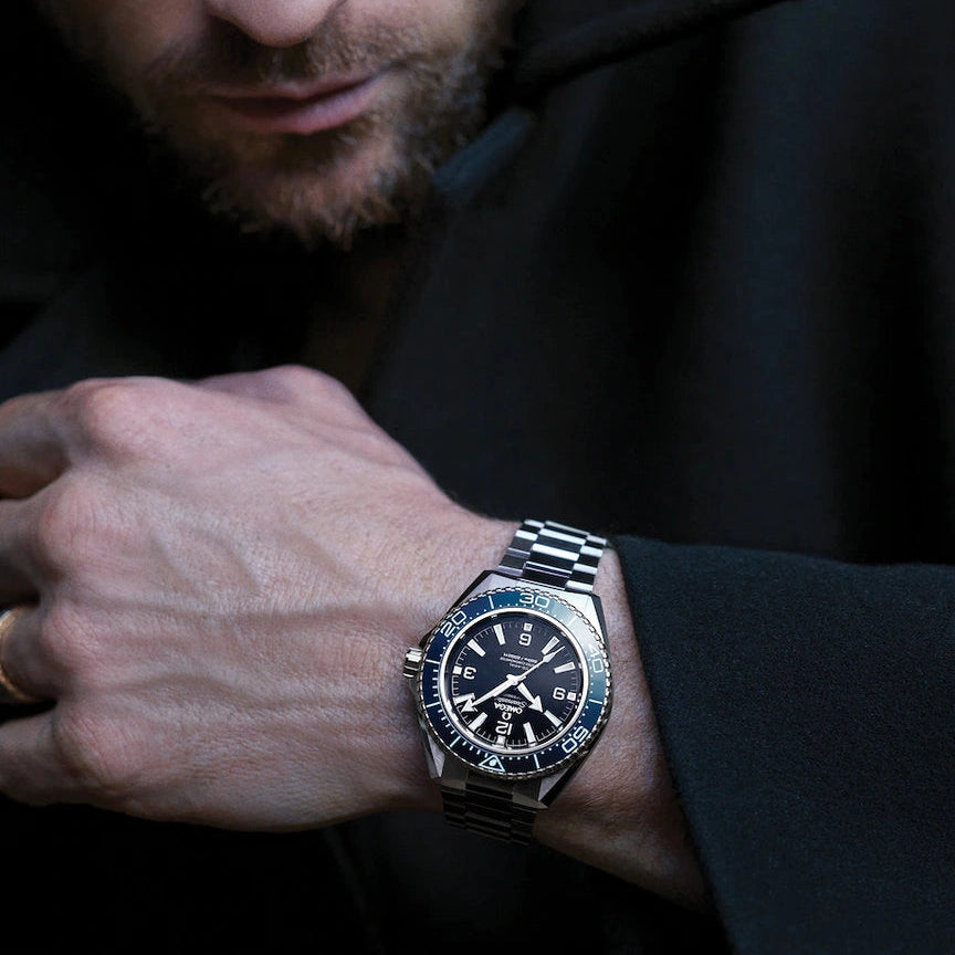 Man wearing a watch with a dark background