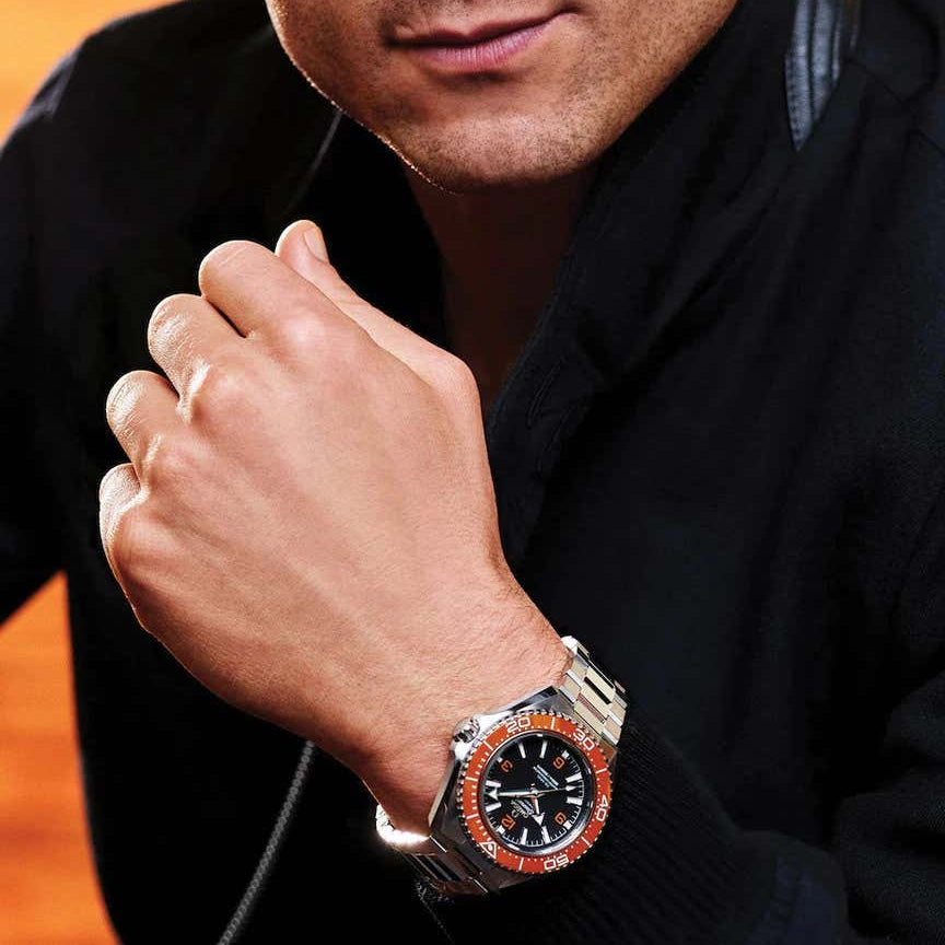 Man wearing a watch with a warm background