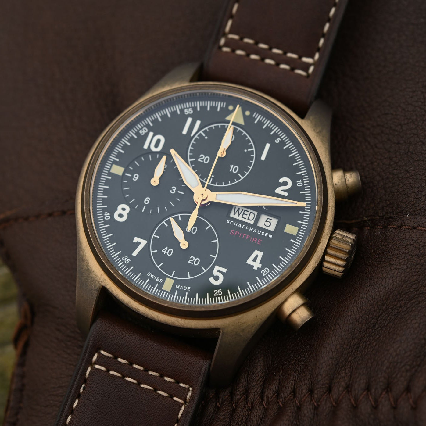 Vintage-style watch with brown leather strap on a textured surface