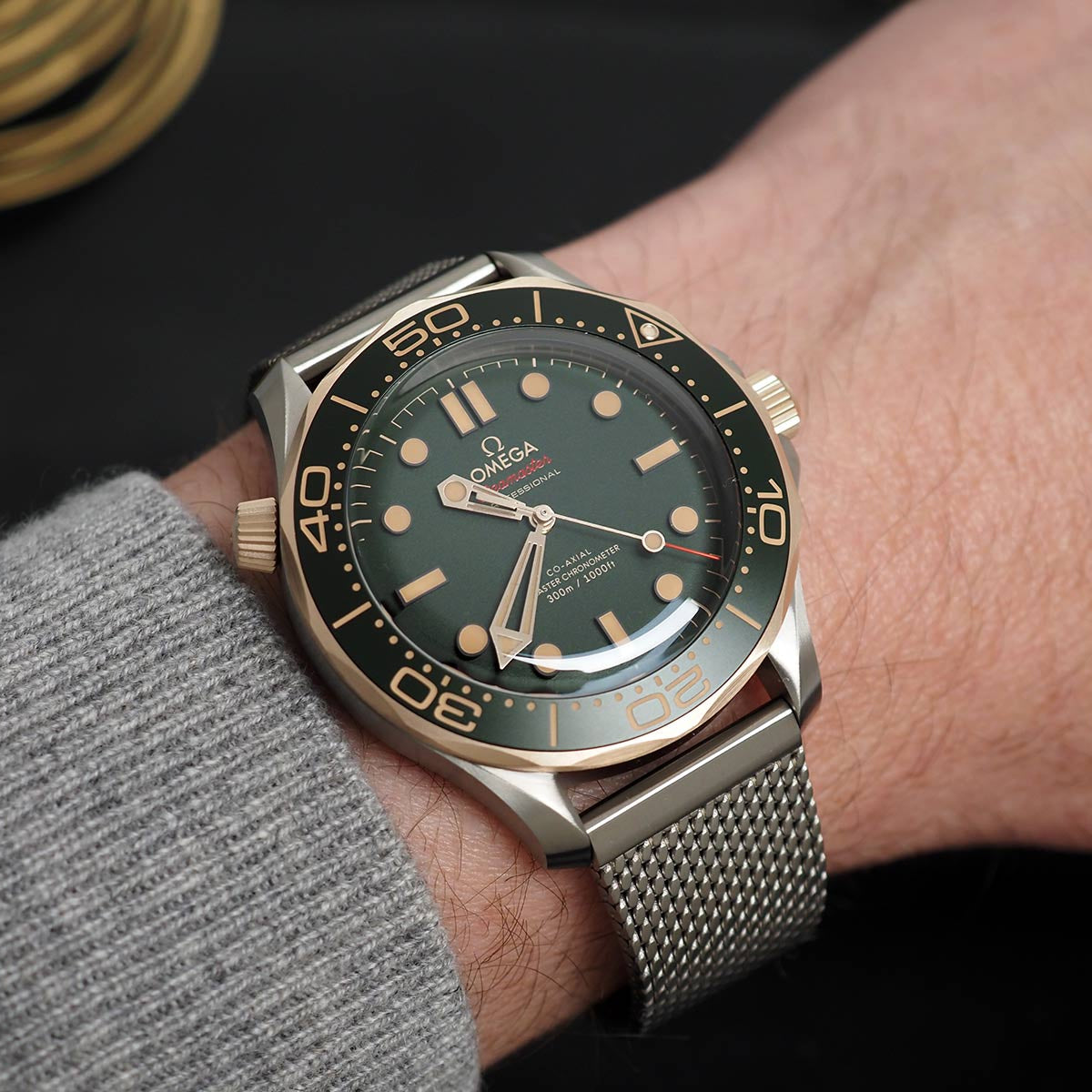 Omega watch on a person's wrist with a dark background