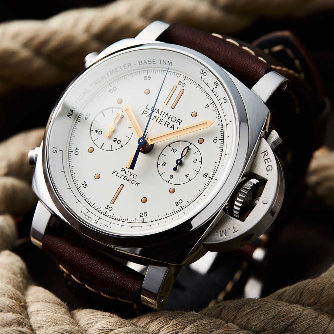 Luxury watch with brown leather strap on a textured surface