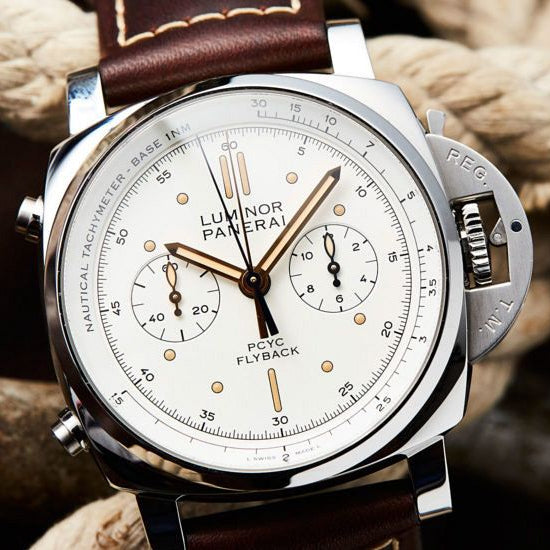 Luxury watch with brown leather strap on a textured background