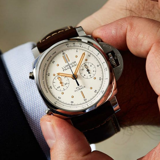 Close-up of a person wearing a detailed wristwatch with a blurred background