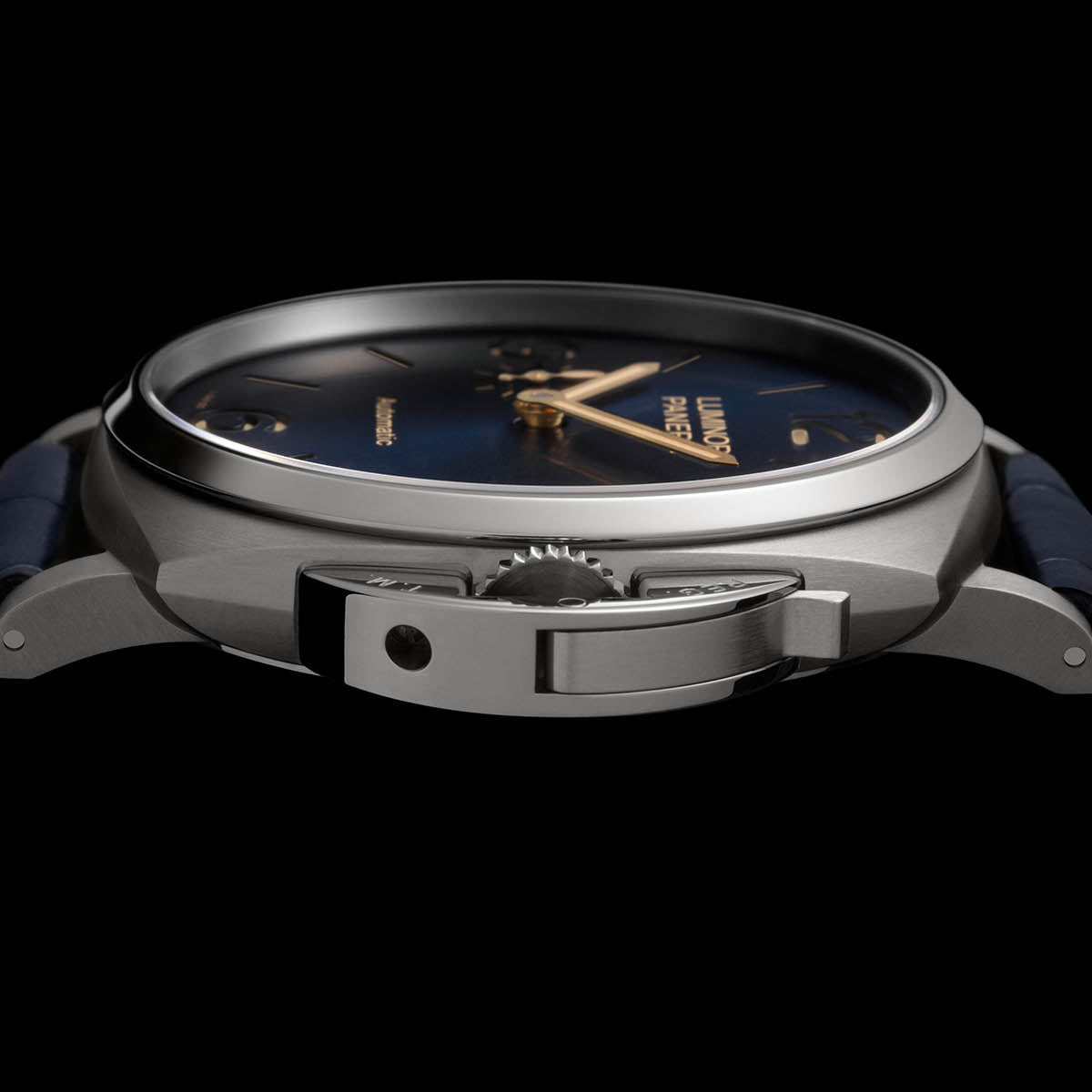 Close-up of a watch with a dark blue face and silver case on a black background