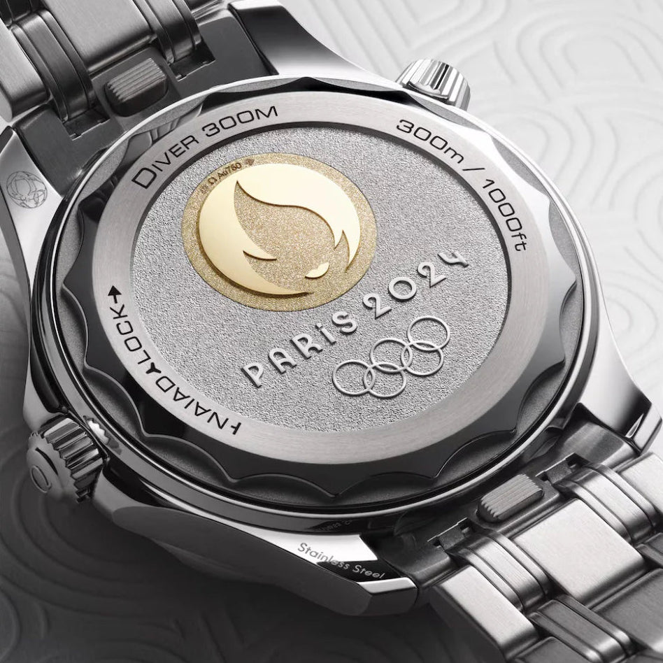 Watch case with 'Paris 2024' and Olympic rings on a metallic background