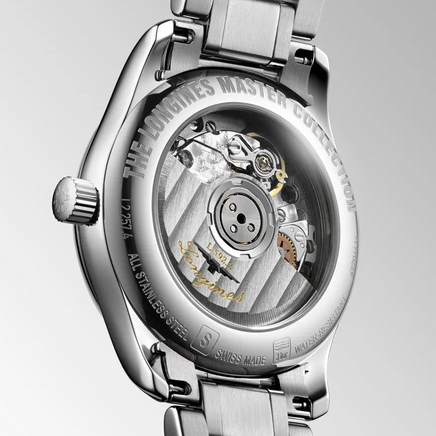 Close-up of a silver watch with visible mechanical components on a light gray background