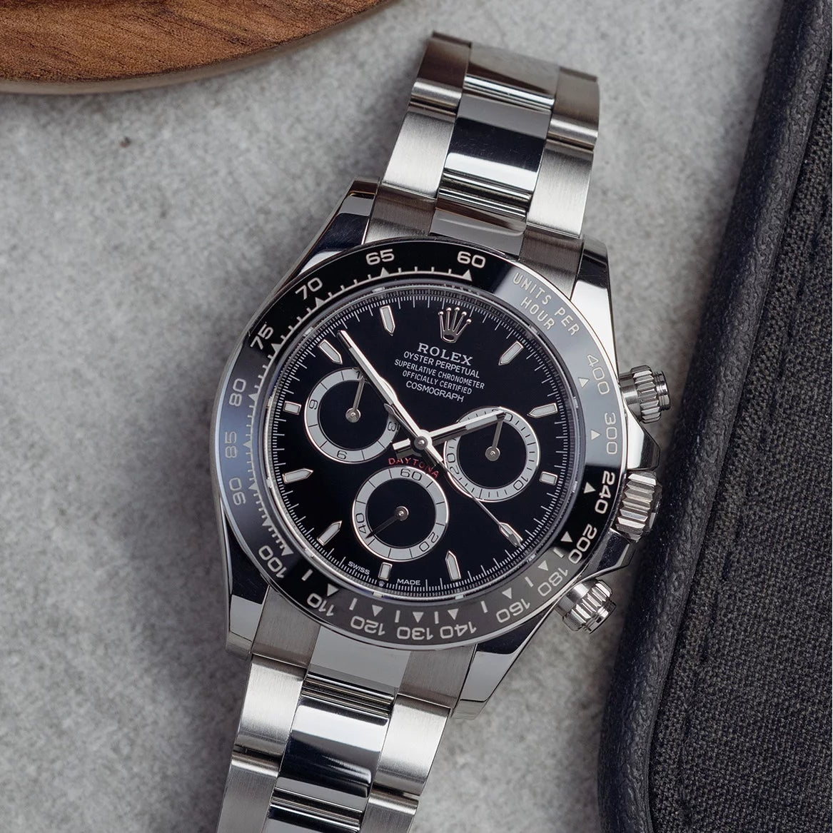 Silver watch with black dial on a textured surface