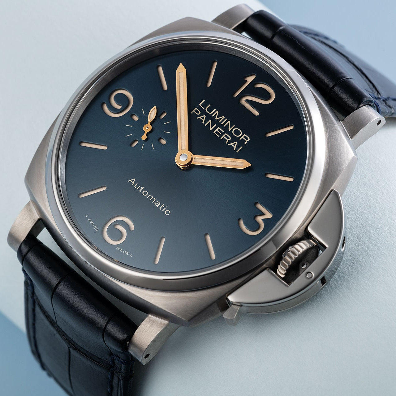 Luminor Panerai watch with black leather strap and blue dial on a light blue background
